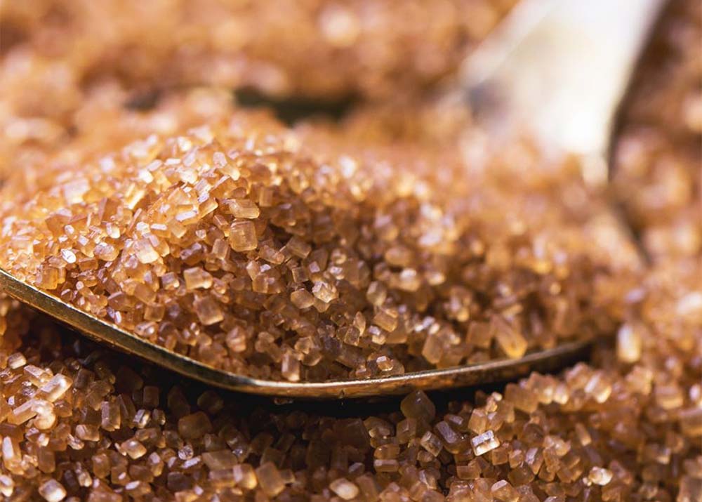 Brown Sugar ICUMSA 600–1200 crystals close-up with a spoon