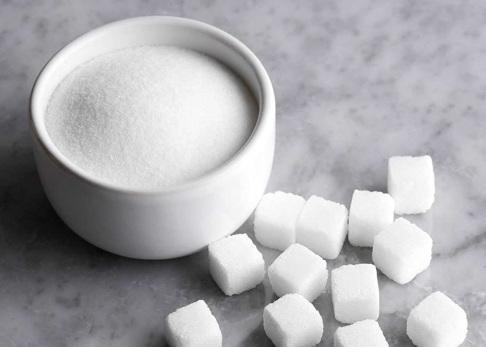 Refined Sugar ICUMSA 150 / 600 cubes and granulated sugar in a bowl