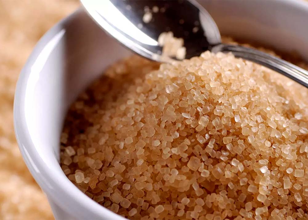 VHP Raw Sugar Export crystals in a bowl with a spoon