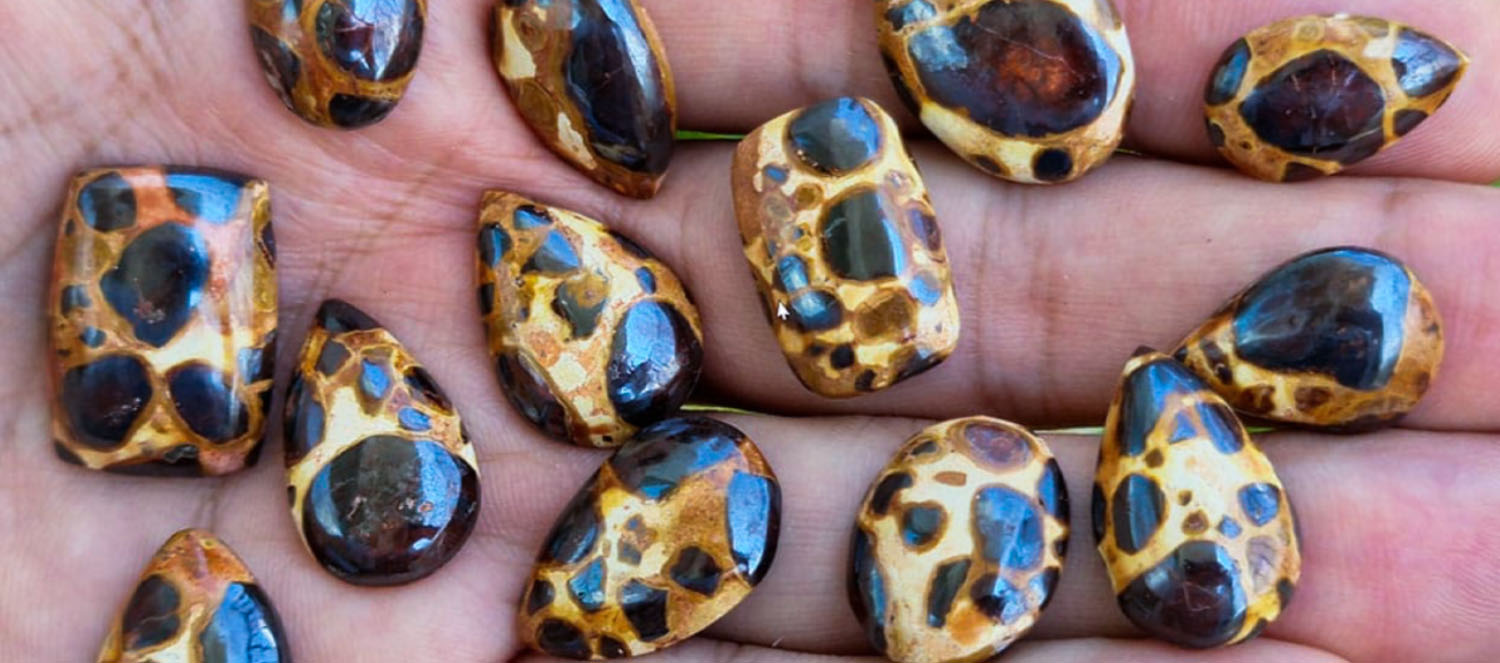 Close-up of bauxite ore pieces in hand showing lateritic mineral texture and composition